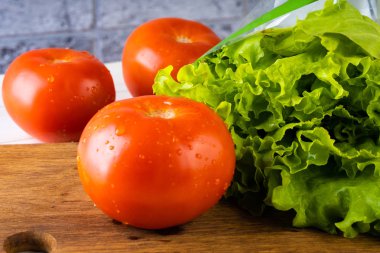 Marul ve olgun kırmızı domates dilimleme tahtasında. Taze meyve.