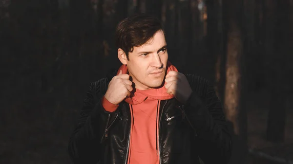 Un hombre guapo posando de noche en el bosque de otoño. Hombre en ropa casual de abrigo de pie en el Parque — Foto de Stock