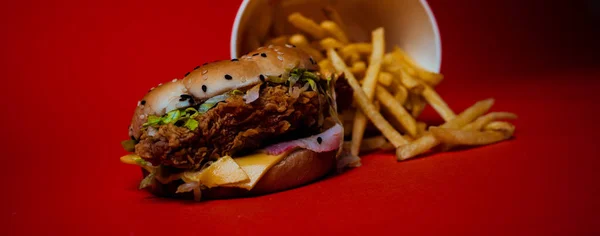 Burger und Pommes auf orangefarbenem Hintergrund. Fettiger Burger und Pommes aus einem Fast-Food-Restaurant isoliert auf orangefarbenem Hintergrund, Kopierraum — Stockfoto