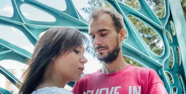 Een jong liefdevol paar poseren tegen de achtergrond van een enorme poort. — Stockfoto