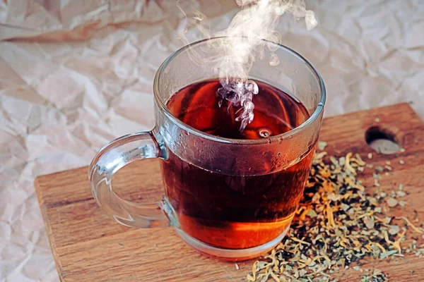 Une coupe de thé noir fraîchement brassé, fuyant la vapeur. Thé noir dans une tasse de verre, boisson chaude — Photo