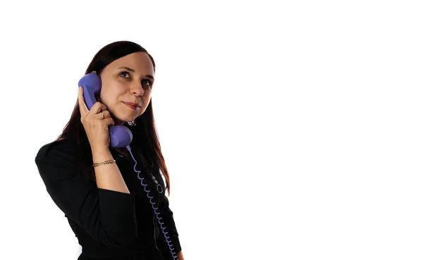 Egy gyönyörű fiatal nő fekete ruhában mosolyog és beszél az otthoni telefonján. Fénymásolási hely. — Stock Fotó