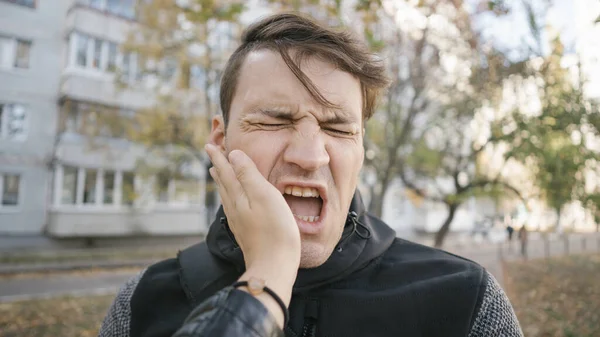 Un homme qui se fait gifler dans la rue. Un homme malheureux et effrayé se fait gifler debout dans le parc — Photo