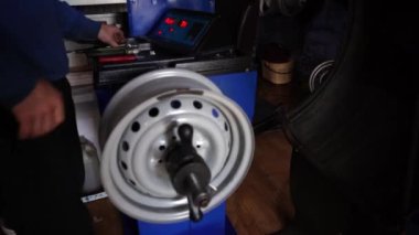 Tekerlek Dengeleme 'ye yakın çekim. Tamir istasyonunda araba tamircisi lastik yenileme ve tekerlek dengeleme yapıyor. Ayarlanmış