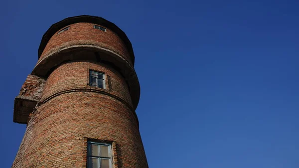 Красный кирпич водонапорная башня против голубого неба — стоковое фото