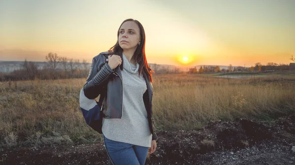Una bella giovane donna è in campo sullo sfondo del tramonto. — Foto Stock