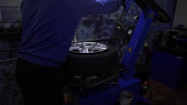Lastik servisinde araba tekerleği dengeleniyor.