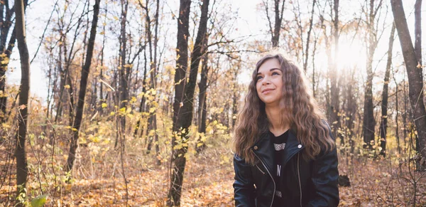 Bella donna posa in piedi nella foresta autunnale. Ragazza in pelle giacca nera camminare nella foresta — Foto Stock