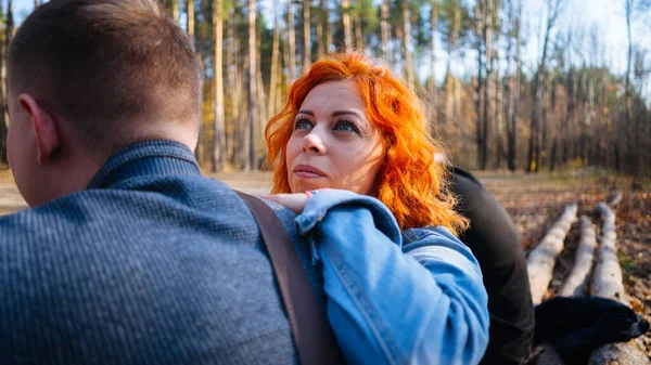 Portrait d'un couple marié dans la forêt d'automne. La femme s'est penchée avec attention sur l'épaule des hommes. — Photo