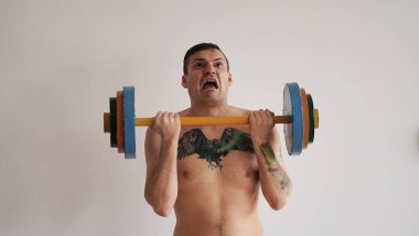 Yetişkin güçlü bir adam spor yapıyor, tüm gücünü kullanıyor..