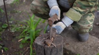 Açık havada odun kesen olgun bir adam. Bahçede baltayla odun kesen adamların ellerini kapatın..
