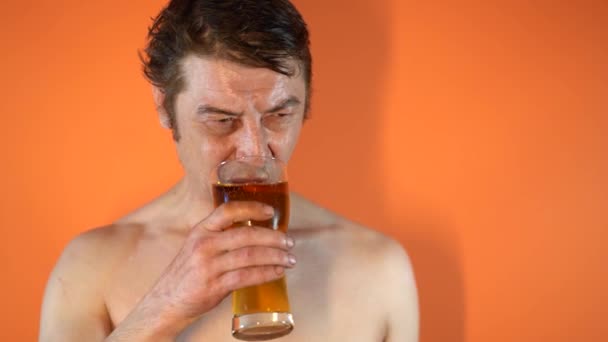 裸の胴を持つ成人男性がグラスからビールを飲む コンセプト アルコール依存症とアルコール依存症の男性 — ストック動画