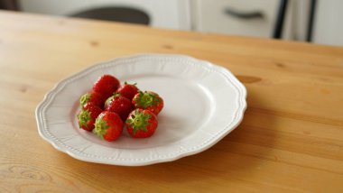 Mutfaktaki masanın üzerindeki olgun çilekleri kapat.