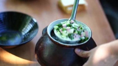 Okroshka - Rus Soğuk Çorbası. Bir kadın temiz havada duran tabaklara çorba döker..