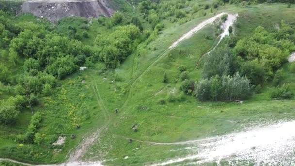 Vista aérea del motociclista que monta en las montañas de tiza en verano. Pájaros vista de conducción extrema en las colinas . — Vídeo de stock