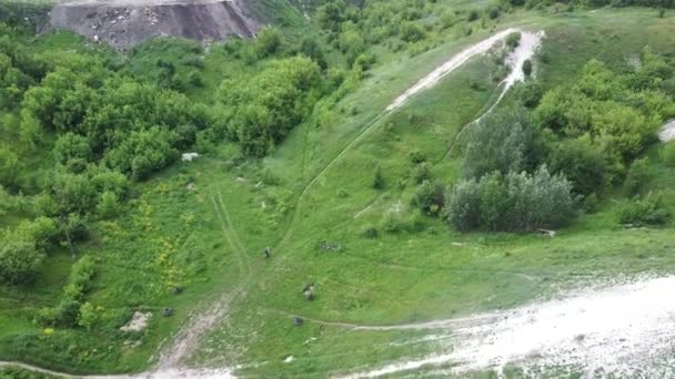 夏にチョークの山に乗ってオートバイの空中ビュー。丘の上の極端な運転の鳥の目のビュー. — ストック動画