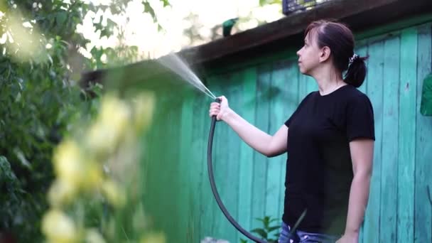 Frau Wässert Den Garten Aus Dem Schlauch Weibchen Sprühen Mit — Stockvideo