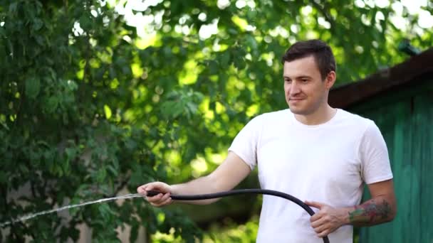 Mann Wässert Den Garten Aus Schlauch Männchen Sprühen Mit Einem — Stockvideo