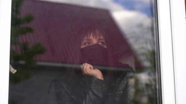 Young Woman Black Medical Mask Looking Out Window Being Isolated — Stock Video