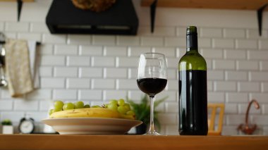 Mutfaktaki tabakta meyve tabağı olan açık şarap ve şarap şişesini kapat..