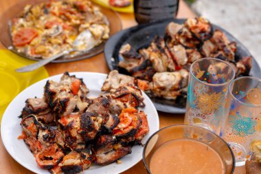 Tabakta kızarmış şiş kebap yakın çekim. Masada domatesli leziz bir barbekü. Açık hava pikniği kavramı