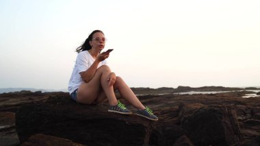 Hoş bir kızın tatilin tadını çıkarması ve Stony Shore 'da cep telefonuyla konuşması..