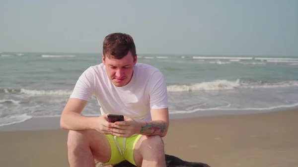 Молодой Человек Держит Смартфон Пляже — стоковое фото
