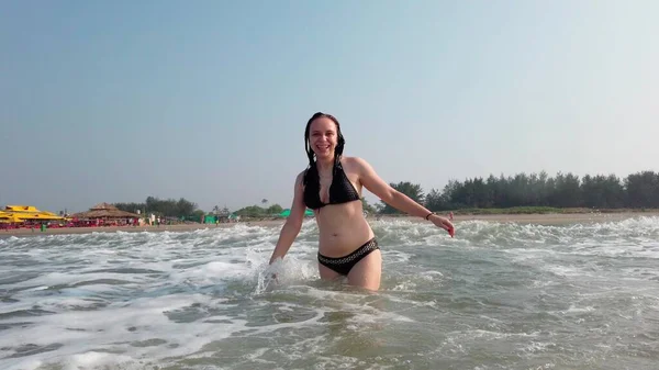 迷人的女人在大海中飞溅的水 摆出姿势拍照 微笑的女孩在海里玩的开心 — 图库照片