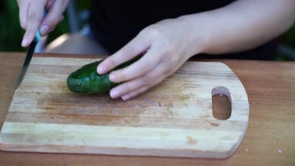 Vrouw Snijden Groene Komkommer Houten Plank Buiten Close Van Vrouwen — Stockvideo