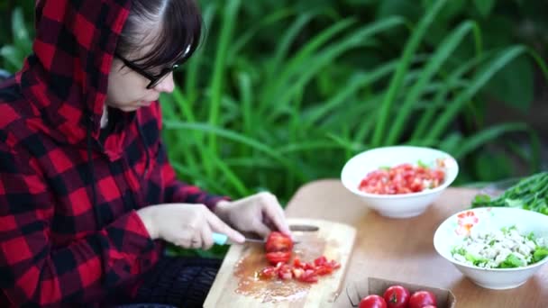 Ung Kvinna Glasögon Skär Tomater Träskiva Utomhus Kvinnliga Skära Grönsaker — Stockvideo