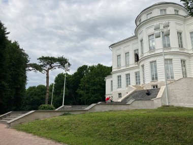 Lüks malikanenin dışından merdiveni ve güneşli yaz gününde birçok penceresi olan.
