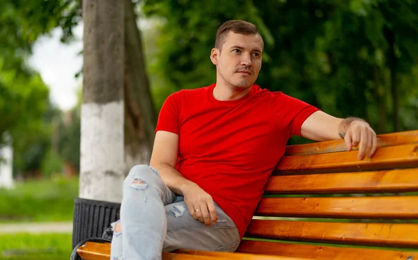 Hombre Adulto Camiseta Roja Jeans Sentado Banco Mirando Hacia Otro — Foto de Stock