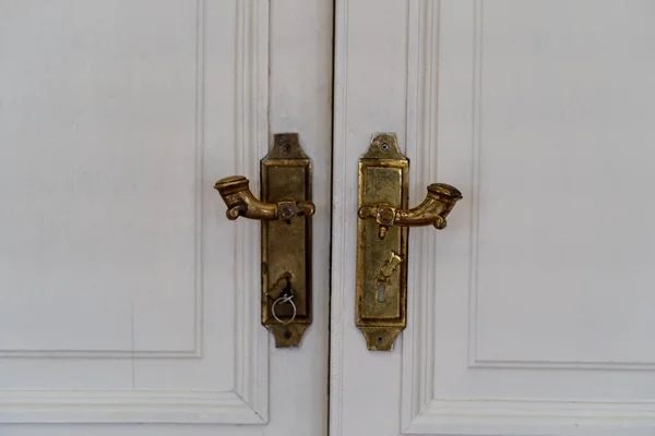白い閉じたダブルドアのクローズアップ ドアの金メッキドアハンドル — ストック写真