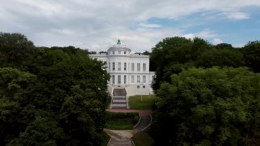 Lüks malikanenin ön cephesi. Lüks malikanenin dışından merdiveni ve güneşli yaz gününde birçok penceresi olan.