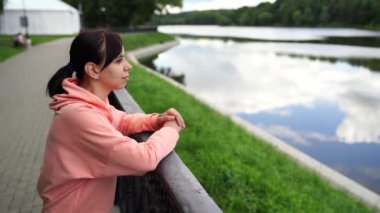 Rıhtımda duran genç bir kadının portresi. Güzel manzaranın tadını çıkaran bir kadının bakışlarını kapat..