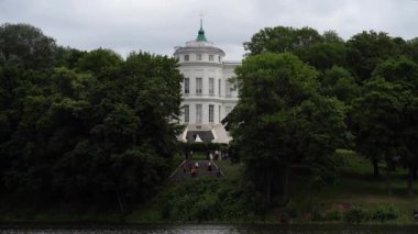 Lüks malikanenin ön cephesi. Lüks malikanenin dışından merdiveni ve güneşli yaz gününde birçok penceresi olan.
