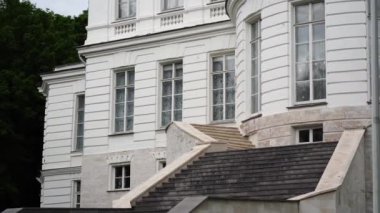 Lüks malikanenin dışından merdiveni ve güneşli yaz gününde birçok penceresi olan.