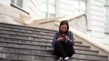 Cep telefonunu kullanan genç bir kadın..