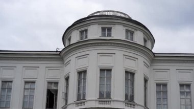 Bulutlu bir havada malikanenin kapağını kapatın. Bulutlu gökyüzünün arka planında tarihi beyaz saray.