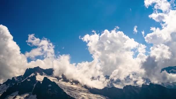 Χιονισμένο Βουνό Εναντίον Συννεφιασμένου Ουρανού Από Κάτω Λευκά Σύννεφα Επιπλέουν — Αρχείο Βίντεο