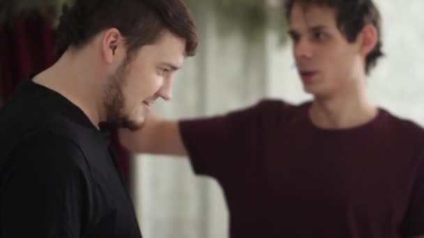 Két férfi egymás arcára akasztja a ruhacsipeszt. Közelkép őrült férfiakról, akik bántják egymást.. — Stock videók