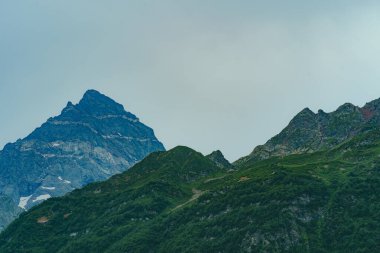 Güneşli bir günde parlak bulutlu gökyüzüne uzanan muhteşem kayaların zirveleri.