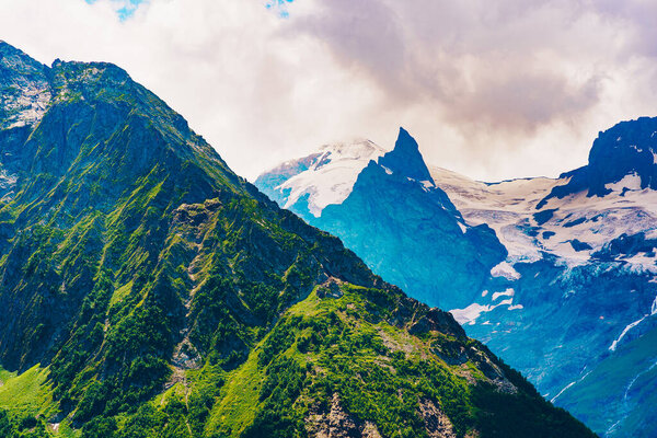 Peaks of magnificent rocks located against bright cloudy sky on sunny day in nature