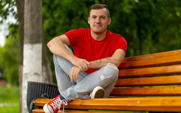 Homem Adulto Camiseta Vermelha Jeans Sentado Banco Olhando Para Longe — Fotografia de Stock