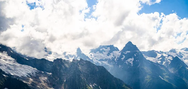 Kayalık dağlar güneşli bir günde bulutlarla örtülüydü. Çarpıcı dağ manzarası