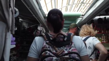 Dombay, Rusya 26 Temmuz 2020: Sırt çantalı genç bir kadın markette yürüyor. Arkadan bakan kadın turist pazar yerine gider ve hediyelik eşya arar..