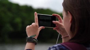 Yetişkin kadın turist cep telefonuyla fotoğraf çekiyor..