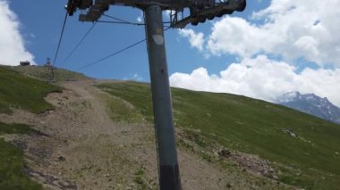Bulutlu havada, dağın tepesinde bir kablo var. Dağlık arazide bankları olan modern bir halat..