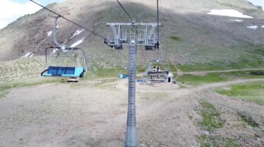 Bulutlu havada, dağın tepesinde bir kablo var. Dağlık arazide bankları olan modern bir halat..