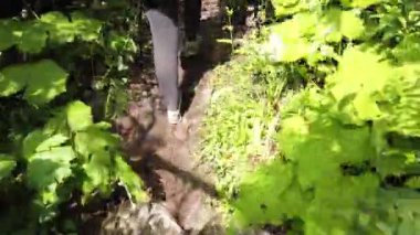 Dombay, Rusya 26 Temmuz 2020: Bir grup insan ormanlık ve tepelik alanda yürüyüşe çıkıyor. Bulutlu bir günde kayalık yolda yürüyen turistlerin arka manzarası.